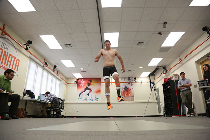 Male jumping in the air before landing on embedded force plates.